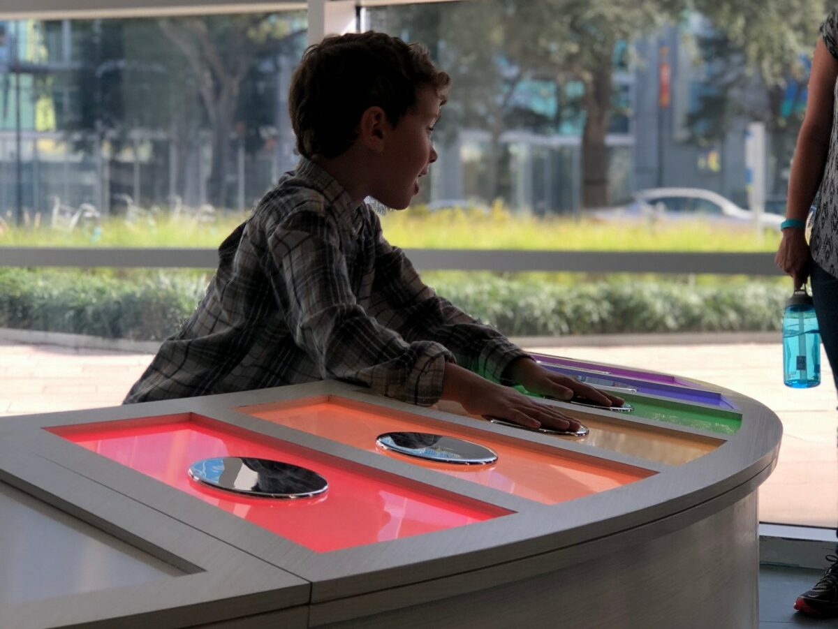 child interacting with light-up interactive touch panels
