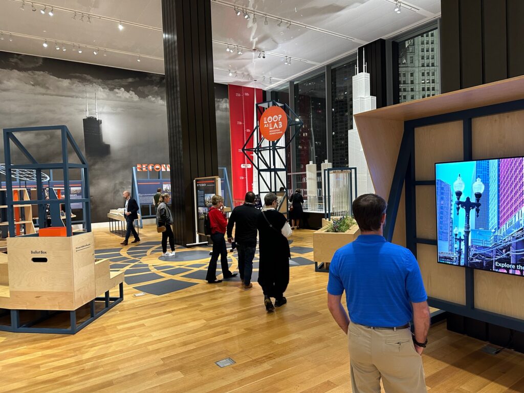 Museum professionals attending the TREX Traveling Exhibitions Forum chatting and exploring the exhibit galleries at the Chicago Architecture Center prior to the start of the presentation.